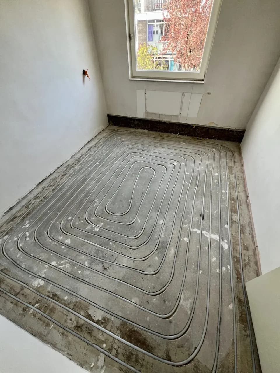 Ingefreesde slangen voor vloerverwarming in een slaapkamer